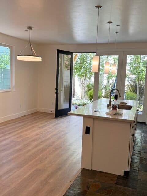 Bright modern kitchen with island and large windows overlooking garden.