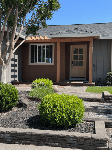 Contemporary house with front porch, garden, and landscaping.